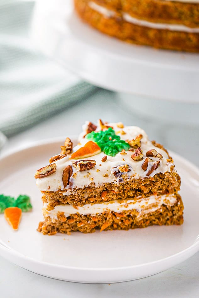45 degree shot of one slice of gluten free carrot cake on a white plate