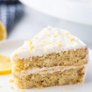 Portrait side shot of a slice of gluten free lemon cake on a white plate