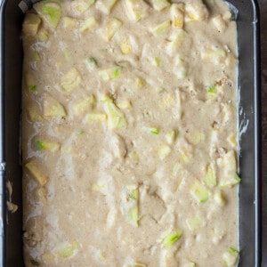 Overhead view of apple cake batter in a 9x13 pan