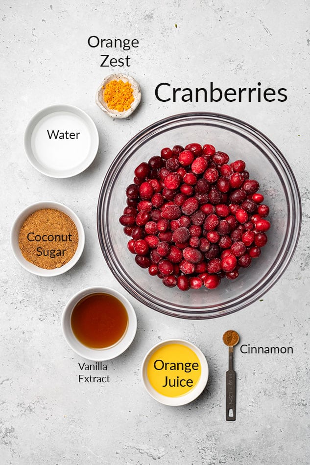 Overhead view of labeled ingredients for homemade cranberry sauce in individual bowls