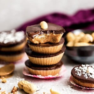 Four chocolate peanut butter cups stacked on top of each other surrounded by more healthy peanut butter cups.