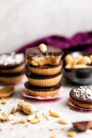 Four chocolate peanut butter cups stacked on top of each other surrounded by more healthy peanut butter cups.