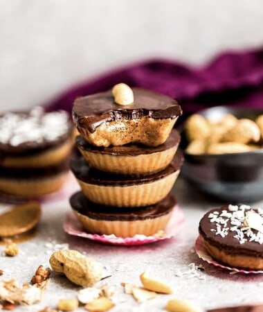 Four chocolate peanut butter cups stacked on top of each other surrounded by more healthy peanut butter cups.