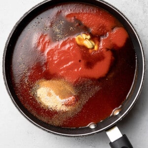 Top view of tomato sauce, balsamic vinegar, mustard and seasonings in a large pot