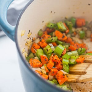 Sautéed onions, garlic, celery, carrots and herbs in a blue pot