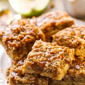 A pile of pear bars with caramel sauce on a white plate