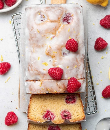 Flat lay of a raspberry lemon loaf with two slices on a wire rack