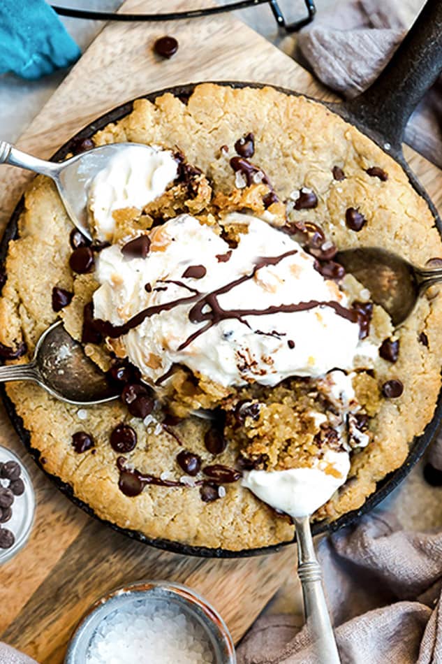 Close-up top view of skillet cookie in a cast iron pan with dairy-free ice cream and a spoon