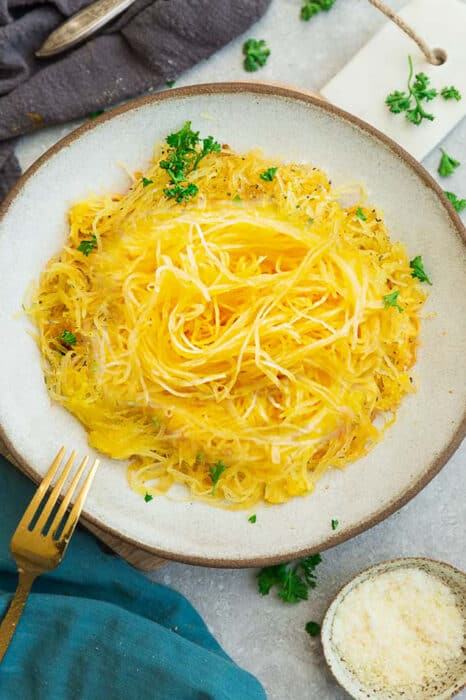 Overhead view of a bowl of spaghetti squash garnished with fresh parsley