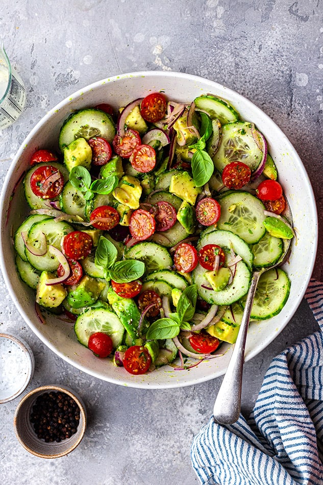 Overhead view of a bowl of Cucumber Tomato Salad with a spoon