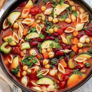A pot of vegan minestrone soup in a grey cast iron dutch oven
