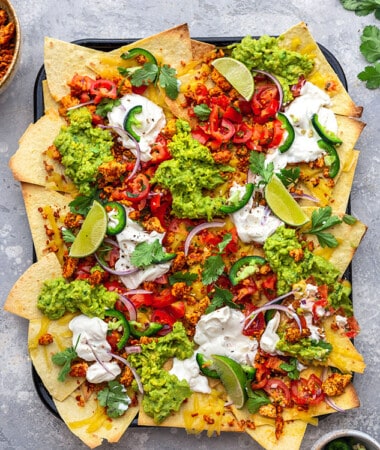 An overhead shot of a platter of loaded vegan nachos on a granite countertop