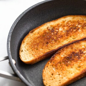 Two slices of toasted sourdough bread in a nonstick frying pan
