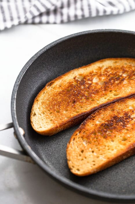 Two slices of toasted sourdough bread in a nonstick frying pan