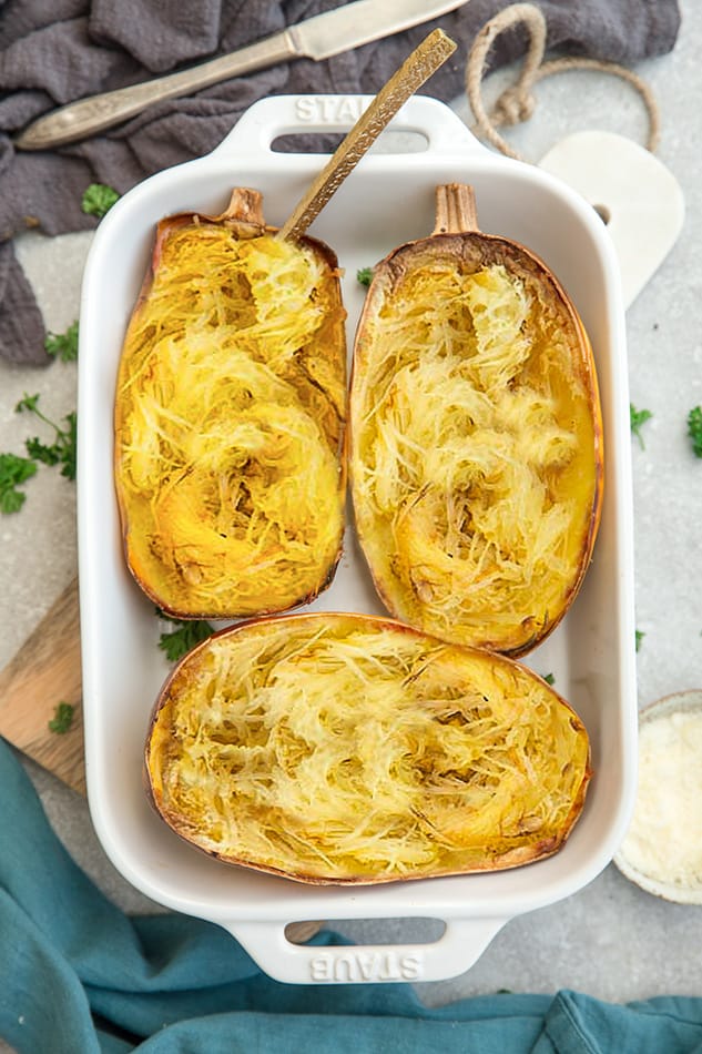 Overhead view of spaghetti squash halves in a baking dish