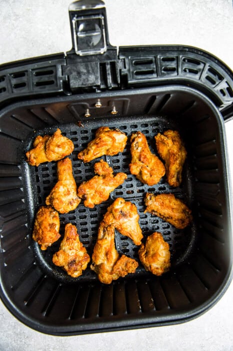 Close-up view of crispy chicken wings in an air fryer basket