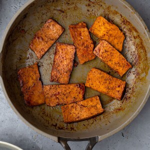 Marinated and seared tofu slices in a non-stick pan