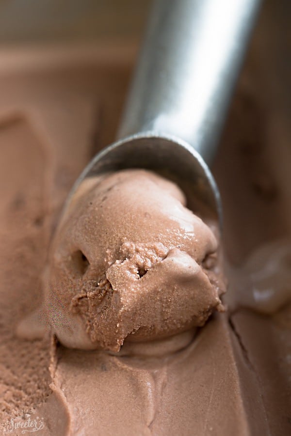 Close-up image of chocolate banana ice cream being scooped into silver spoon.