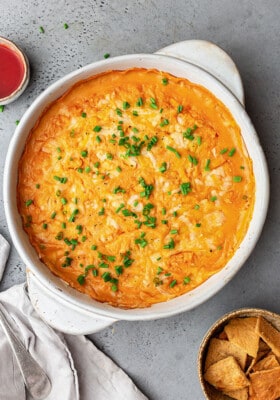 Overhead shot of a batch of vegan buffalo chicken dip in a white round baking dish