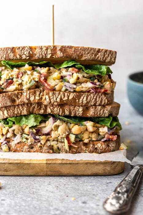 Close-up of easy chickpea salad sandwich stacked on a wooden cutting board