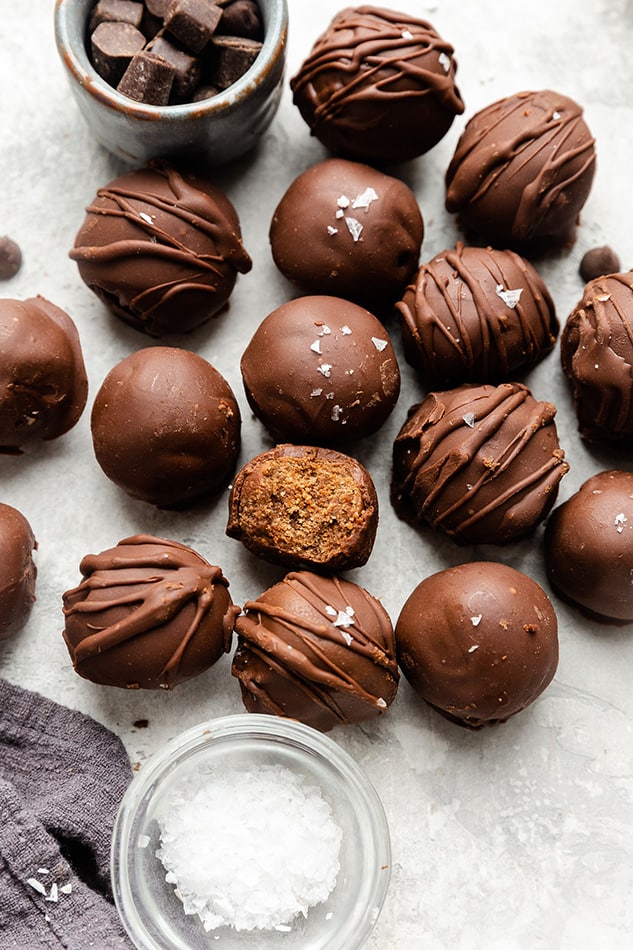 Scattered vegan brownie truffles on a white background