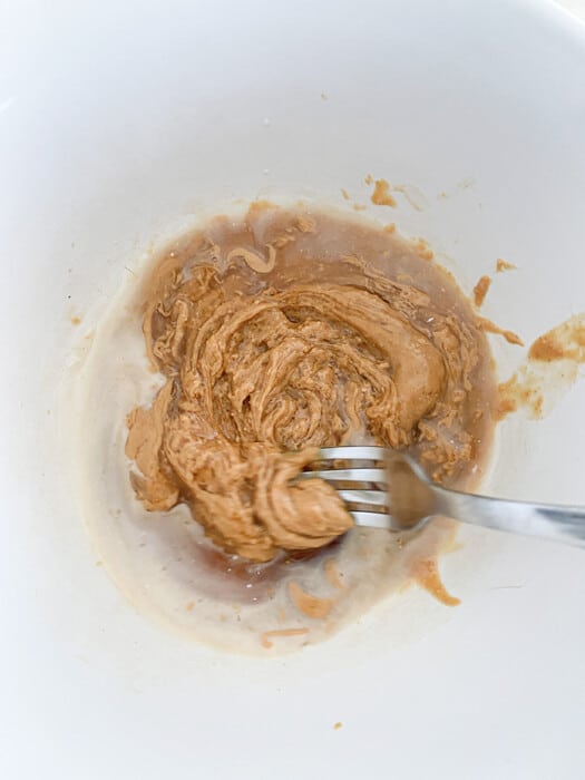 Top view of cookie dough mixture in a white bowl with a fork
