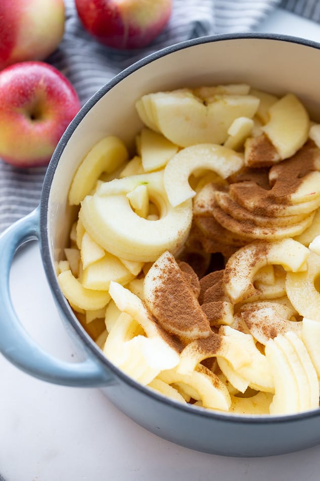 Close-up view of sliced apples with cinnamon in a blue pot