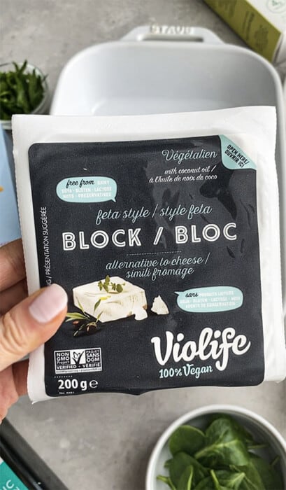 Hand holding a 7-ounce package of Violife Vegan Feta