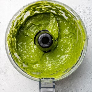 Top view of blended green goddess dressing in a food processor bowl