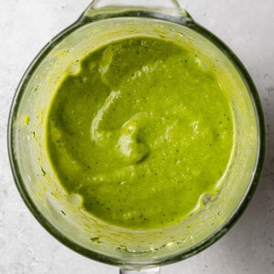 Blended spinach, avocado, frozen mango, frozen pineapple and almond milk in a blender