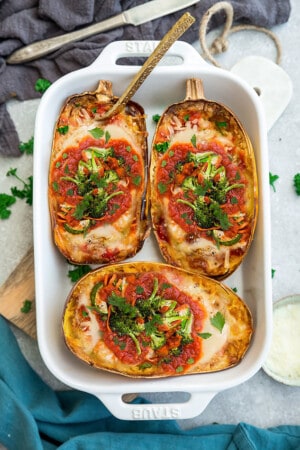 Top view of stuffed spaghetti squash with broccoli in a white rectangle baking pan