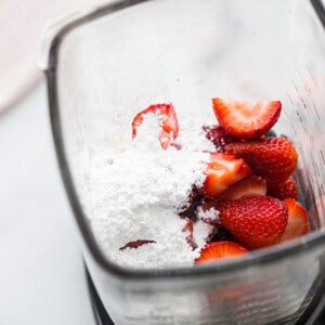 Top view of strawberries and coconut cream in a blender