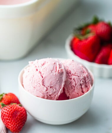 Portrait side photo of homemade strawberry ice cream in a white bowl
