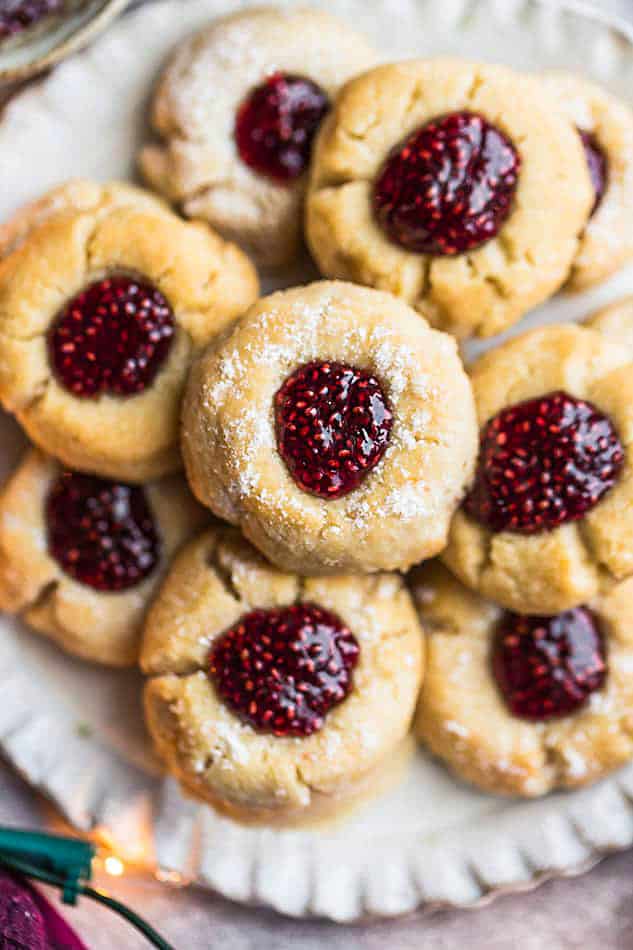 Overhead view of a tray full of thumbprint cookies with berry jam