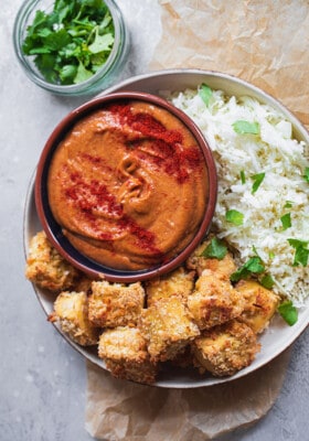 A bowl with tofu nuggets and spicy peanut dip