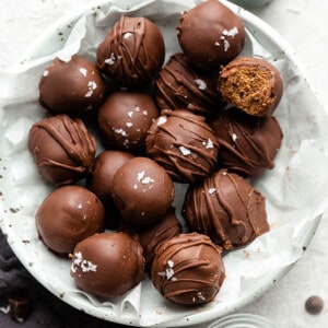 A pile of vegan truffles in a white bowl