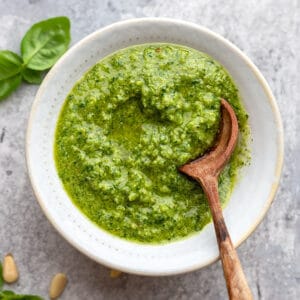 Top view of pesto in a white bowl with a spoon