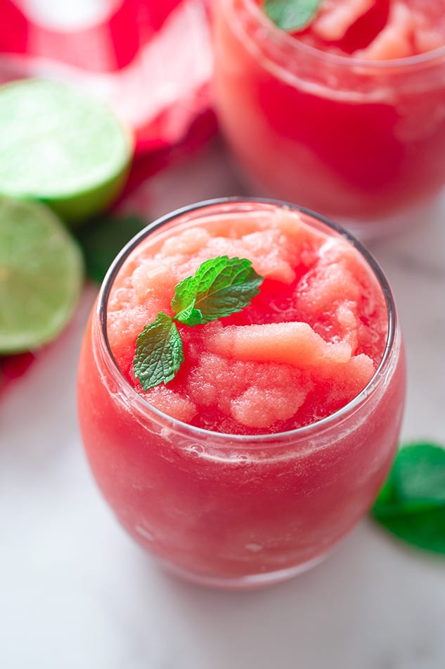 Portrait side shot of a watermelon slushie in a glass cup with mint
