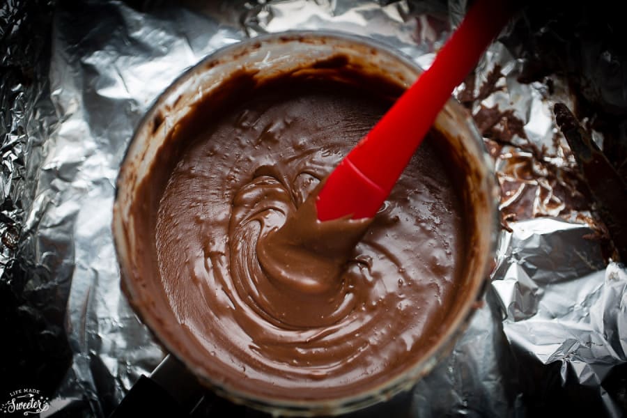 Overhead view of chocolate fudge in a bowl with a spatula