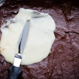Top view of chocolate layers to make peppermint bark in a baking pan