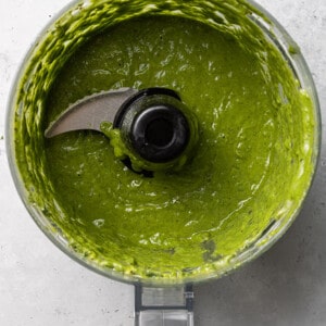 Blended green goddess salad dressing in a food processor bowl