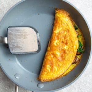 Top view of a cooked omelette on a grey nonstick skillet
