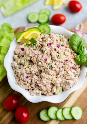 Top view of low carb paleo tuna salad in a white bowl on a wooden board