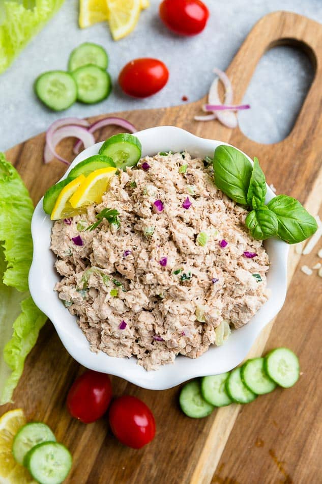 Top view of Whole30 classic tuna salad in a white bowl on a wooden board