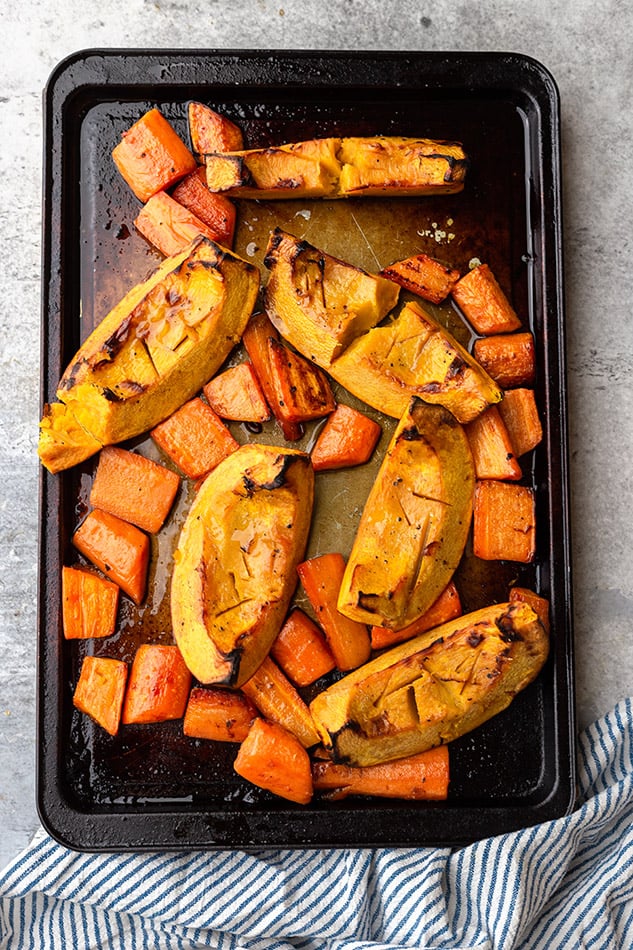 Roasted Pumpkins and Carrots Spread Across a Baking Sheet