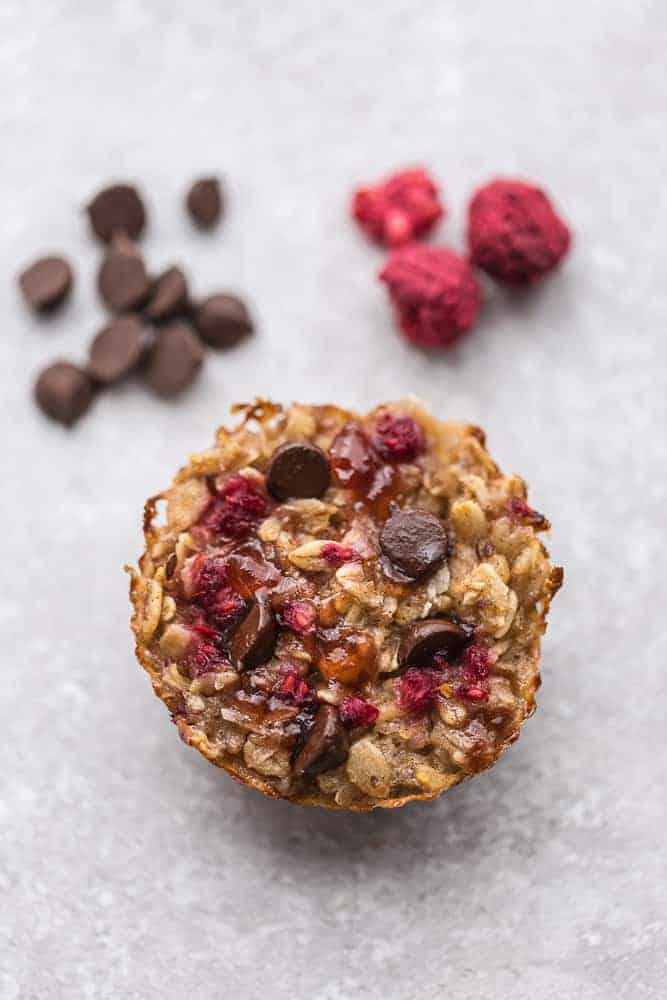 Overhead image of raspberry baked oatmeal cups with oats and chocolate.