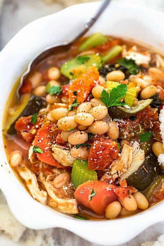 close up image of tuscan chicken soup using colorful vegetables and canned beans