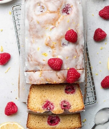 Overhead view of raspberry lemon loaf on a cooling rack with a few slices cut