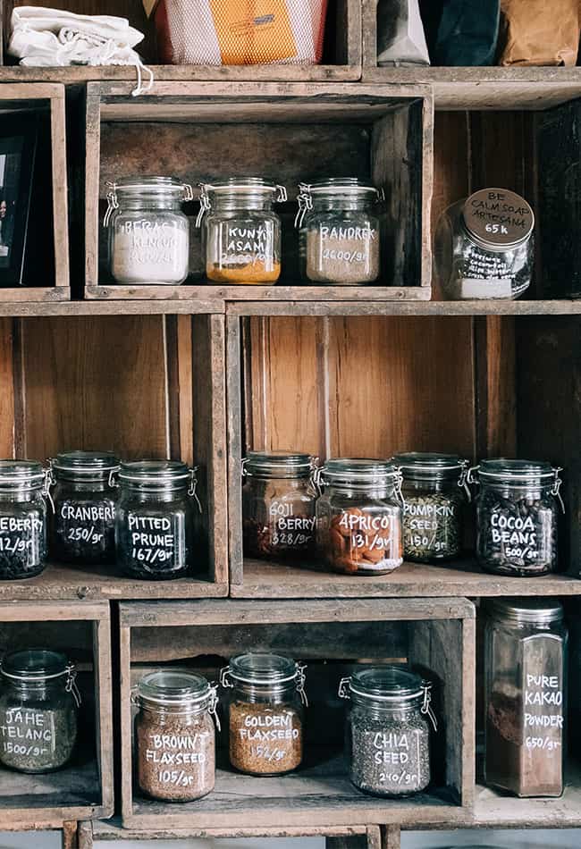 shelf filled with pantry staples such as cocoa powder, fruit, and rice