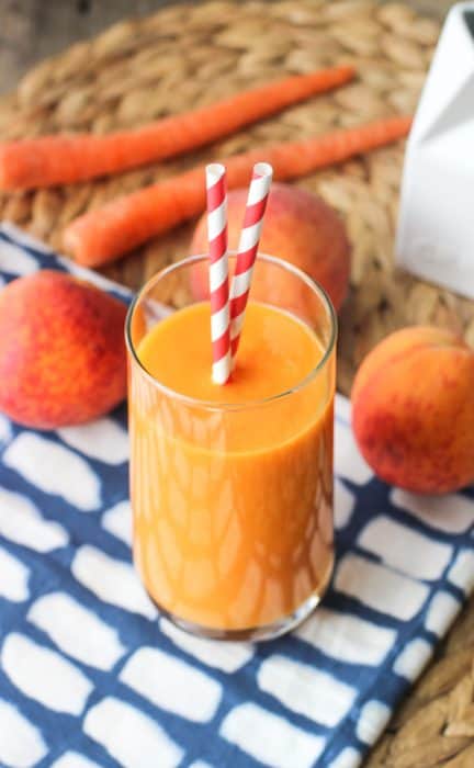 A glass of Power Peach Mango Smoothie with two straws